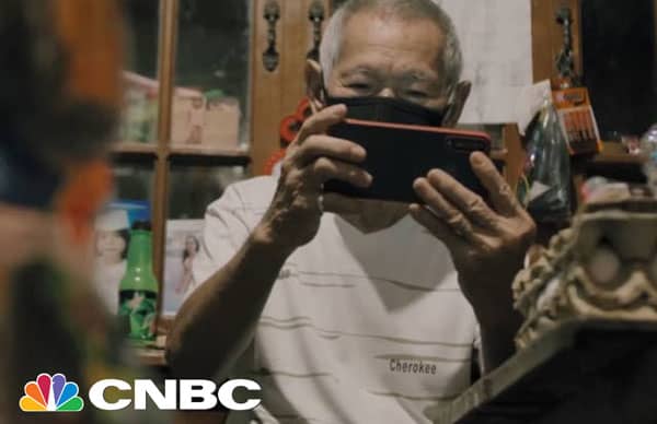 Older Filipino man playing Axie Infinity in his home during the pandemic